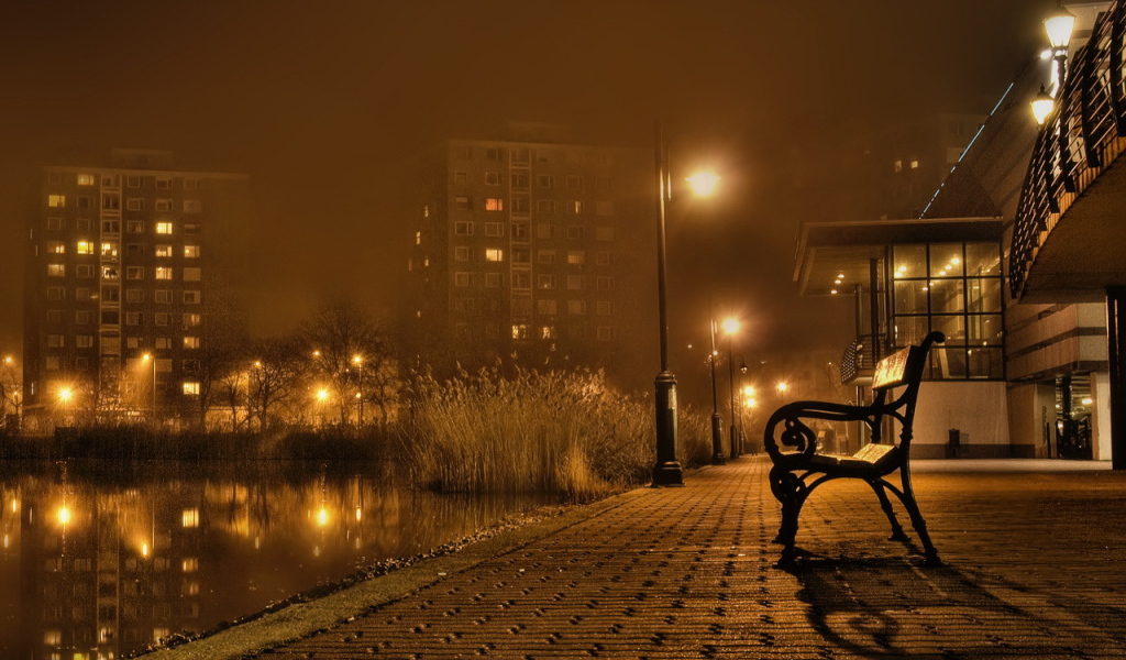 Скамейка около реки в городе