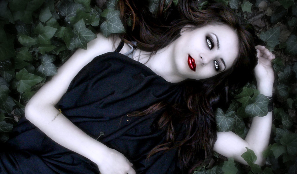 Девушка вампир лежит в листьях