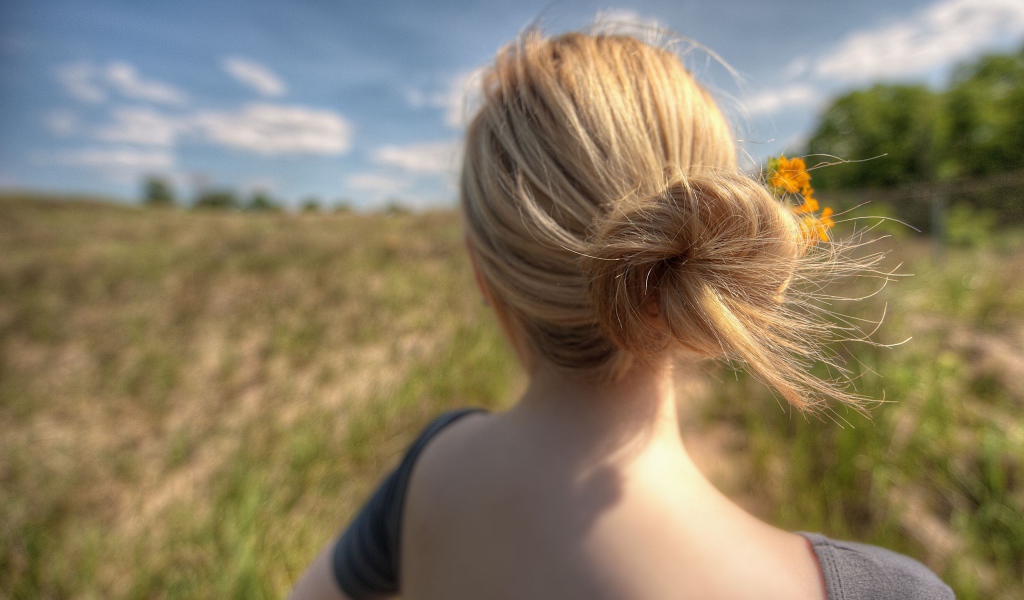 Девушка с цветами в волосах в поле