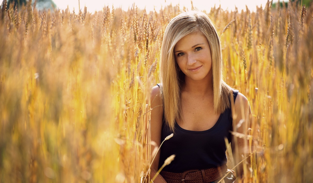 Девушка с веснушками среди пшеницы