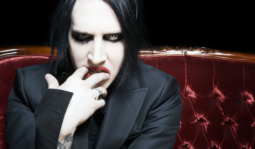Marilyn Manson on a red couch