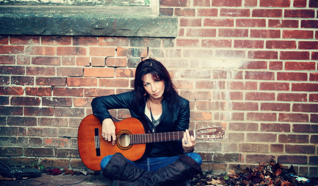Девушка с гитарой у стены