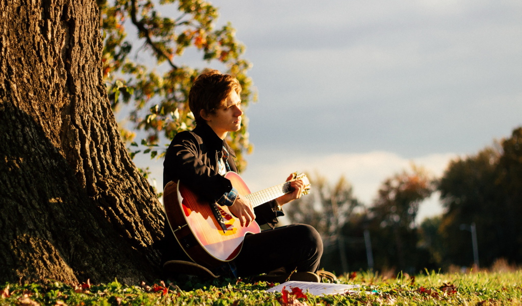 Парень с гитарой у дерева