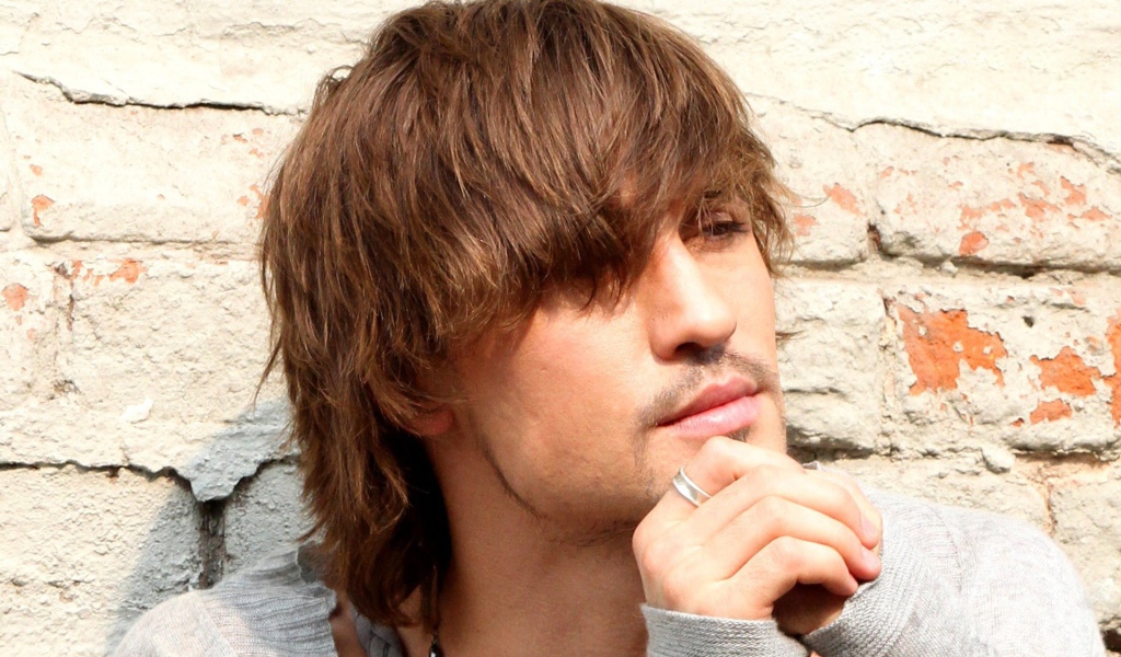 Дима Билан возле кирпичной стены