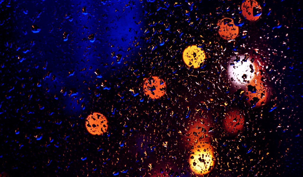 Свет фонарей через мокрое стекло