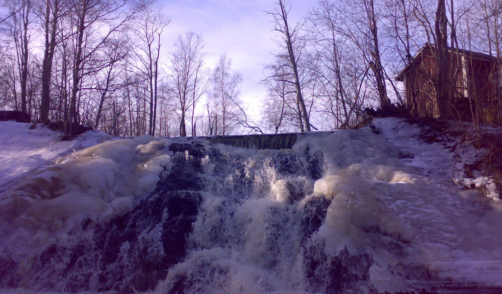 Замерзший водопад и хижина лесника