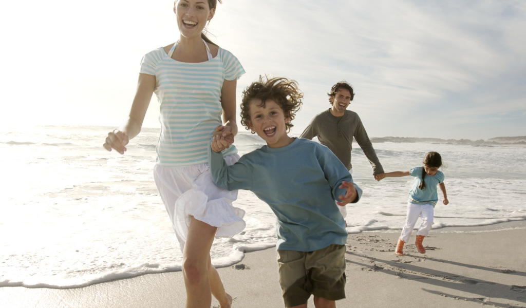 Семья гуляет на пляже