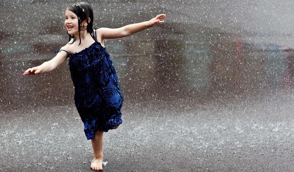 Счастливый ребенок бегает под дождем