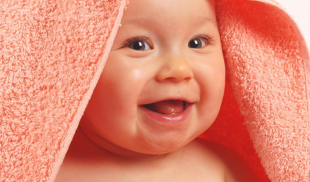 Ребенок в полотенце смеется