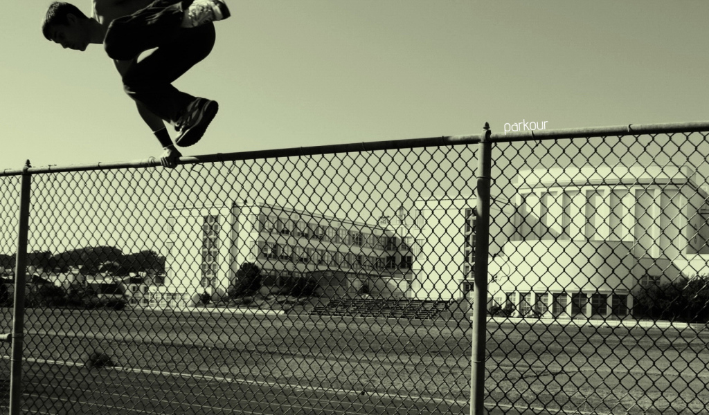 Паркурщик прыгает через забор