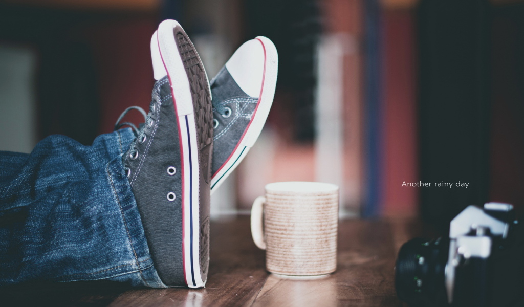 Кеды и чашка на столе