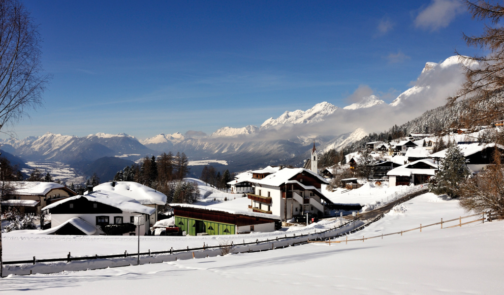 Дома на фоне гор на курорте Зеефельд, Австрия