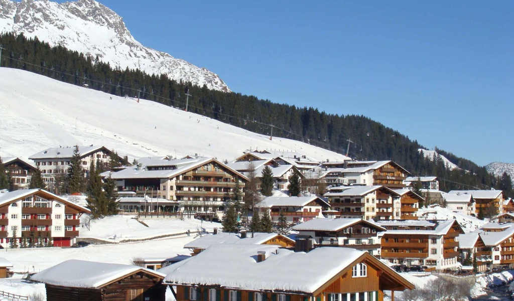 Дома на фоне гор на горнолыжном курорте Лех, Австрия