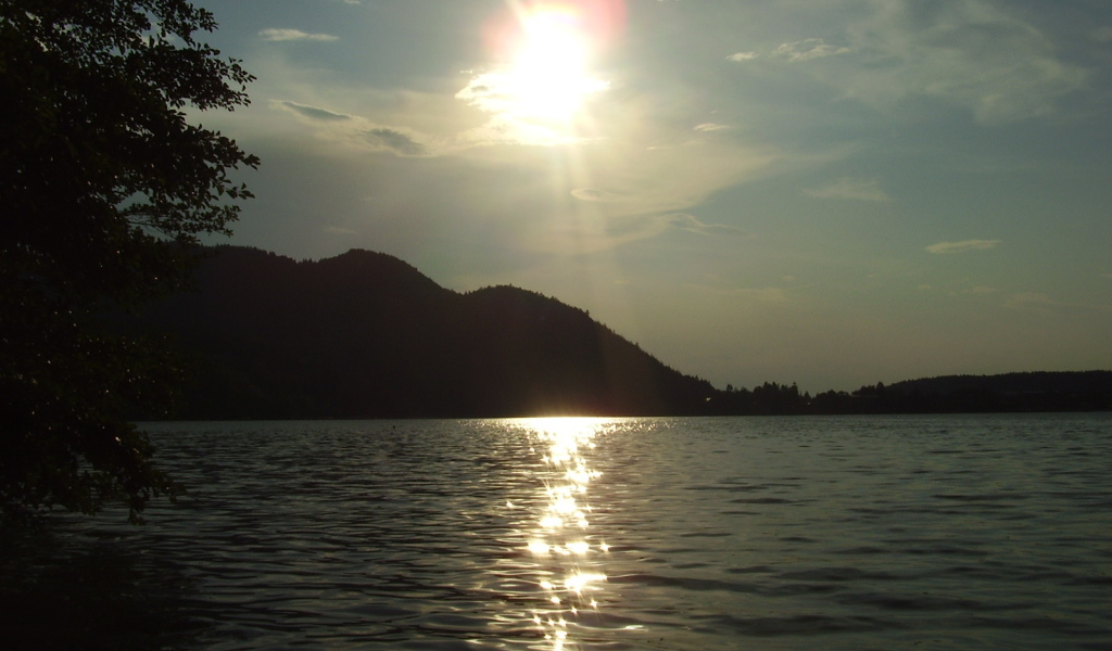 Солнце над водой озера Клопайнер Зее, Австрия