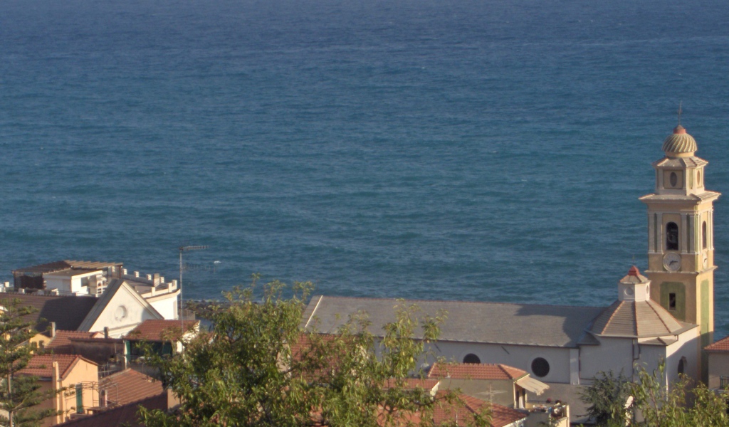 Башня с часами на фоне моря в Санто Стефано аль Маре, Италия