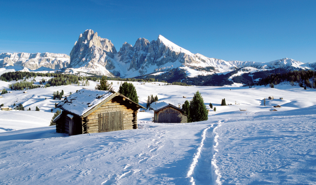 Дома на фоне гор на горнолыжном курорте Валь Гардена, Италия
