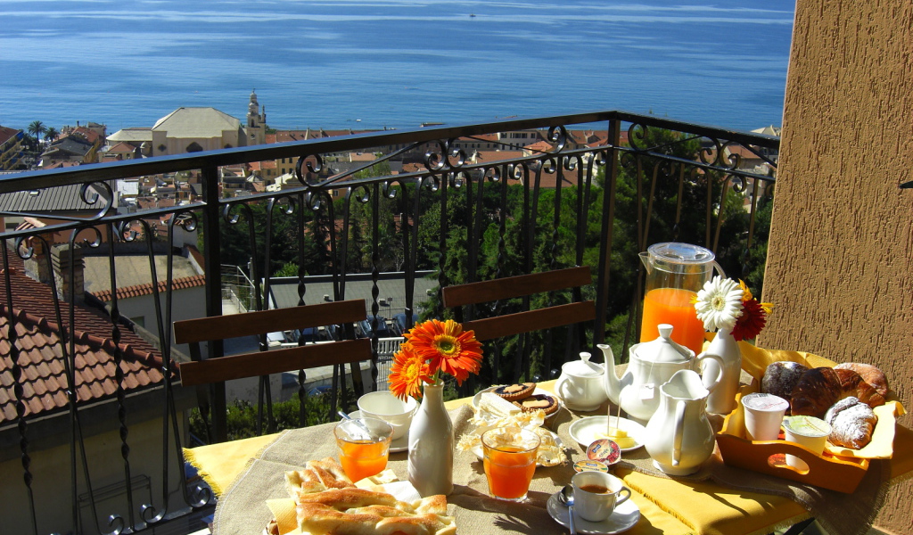 Отдых в кафе на террассе на курорте в Пьетра Лигуре, Италия