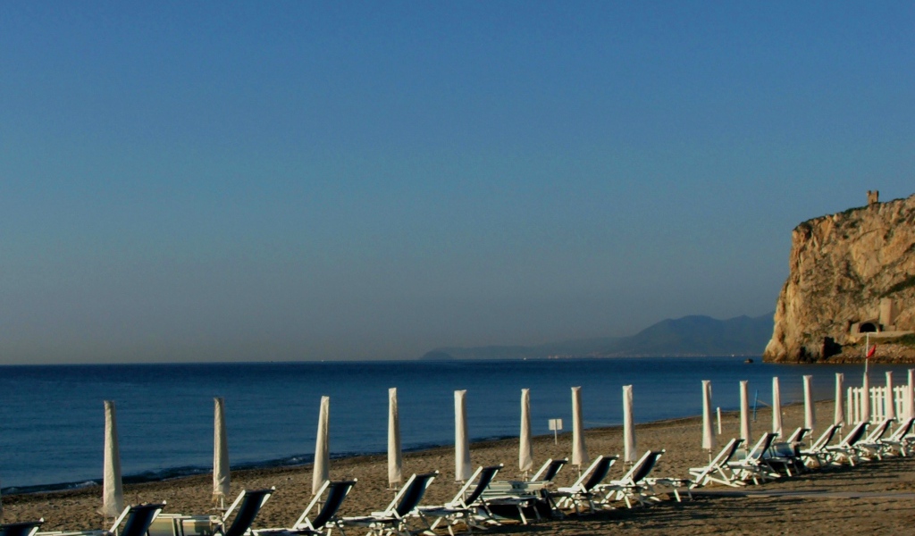 Лежаки на пляже на курорте Финале Лигуре, Италия