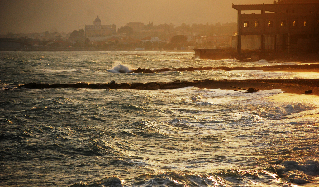 Закат на пляже на курорте в Пьетра Лигуре, Италия