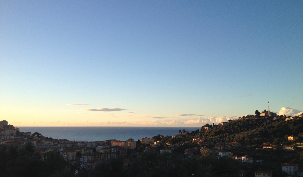 Закат над городом на курорте Империя, Италия