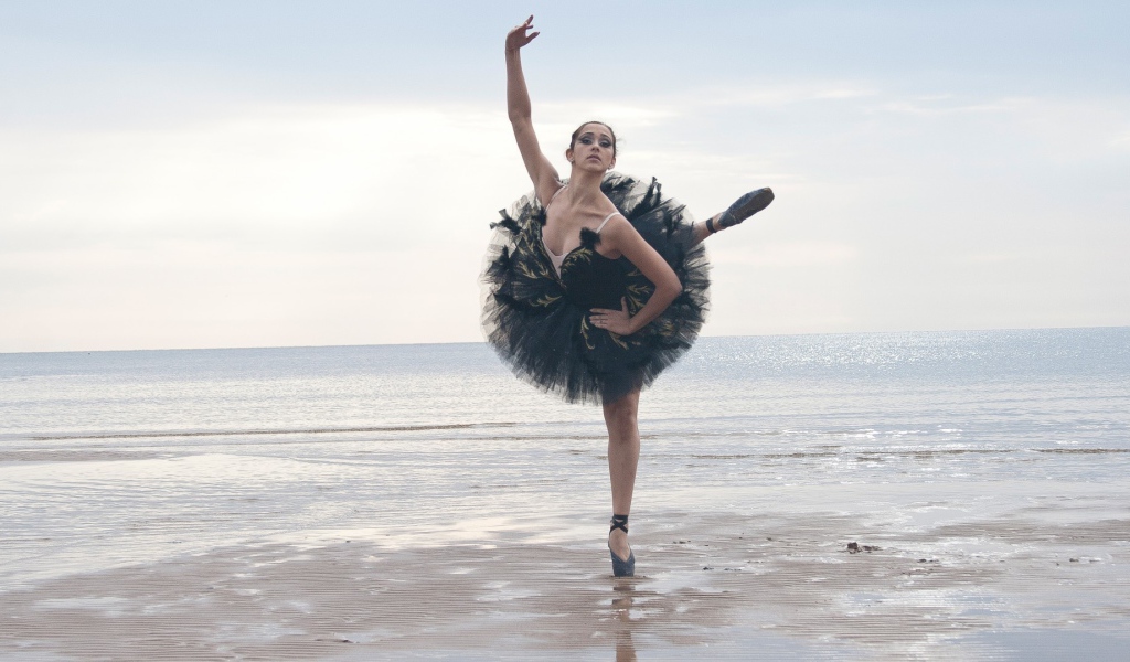 Балерина в черном на пляже