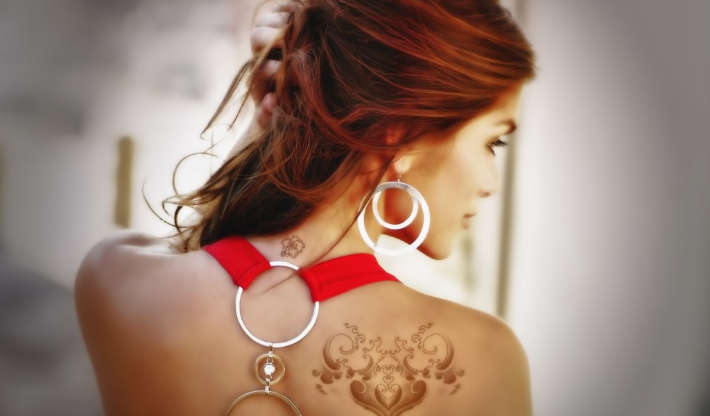 Девушка с татуировками на плече и шее