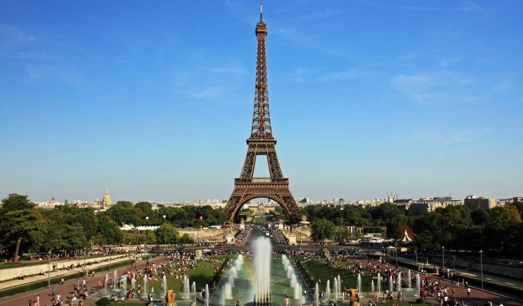 People rest near the Eiffel Tower and fountains