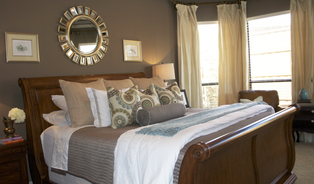 Круглое зеркало над кроватью в спальне