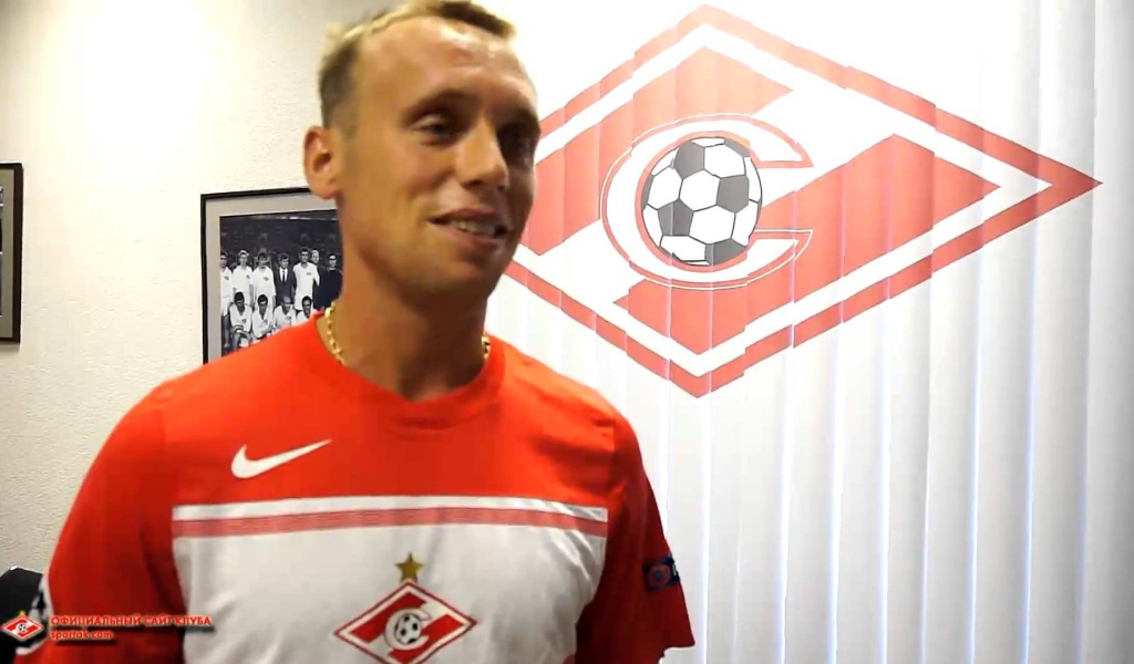 Денис Глушаков полузащитник Спартака на фоне логотипа команды