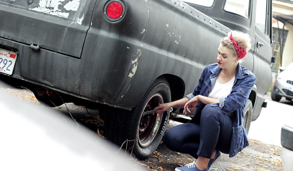 Девушка чинит автомобиль