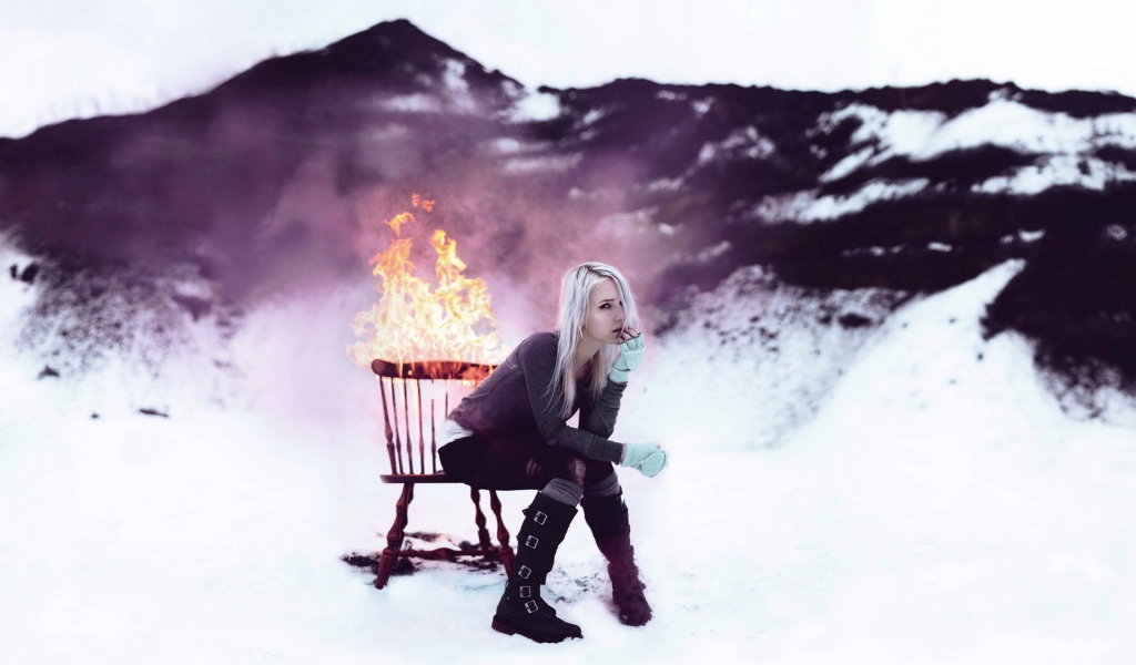 Девушка сидит на горящем стуле