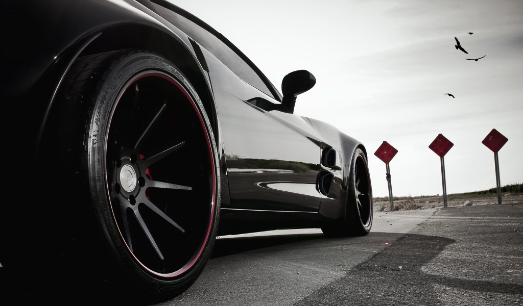 Черный автомобиль перед дорожными знаками