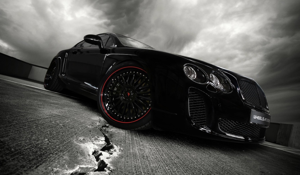 Черный автомобиль на треснувшем асфальте