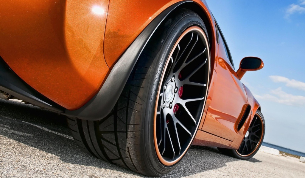 Черные колеса оранжевого авто