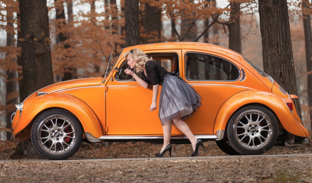 Девушка красит губы у зеркала старого автомобиля