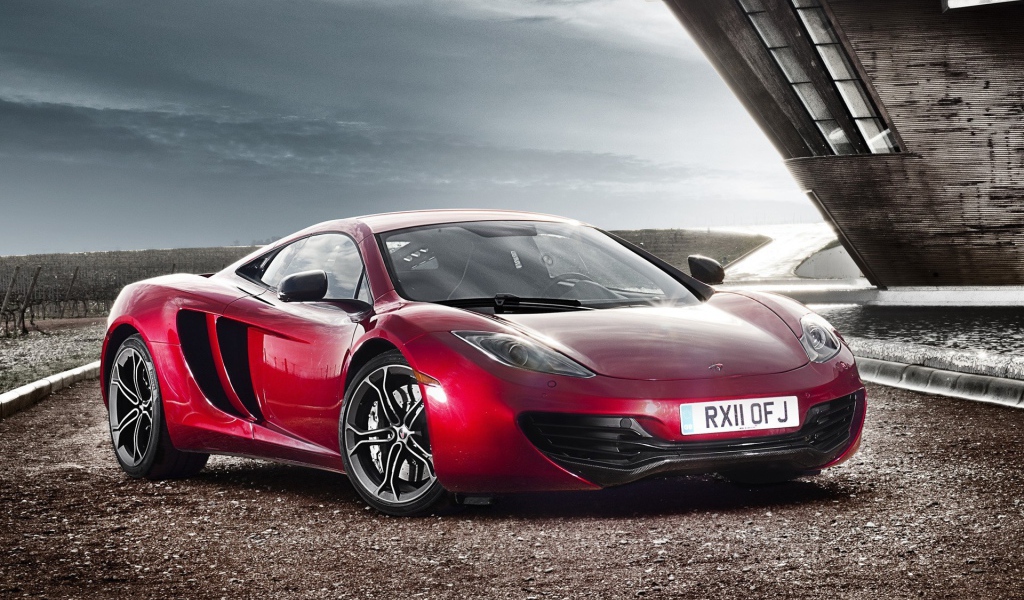 Красный McLaren на коричневом гравии