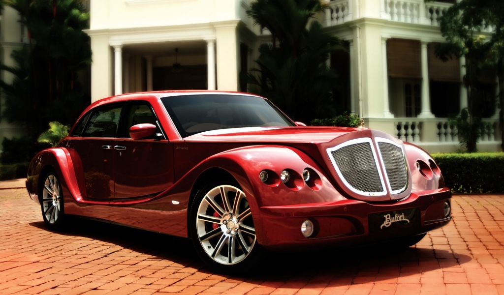 Красный роскошный автомобиль на мощеной дорожке