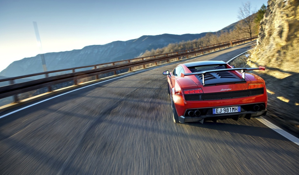 Красный гоночный автомобиль на горной дороге