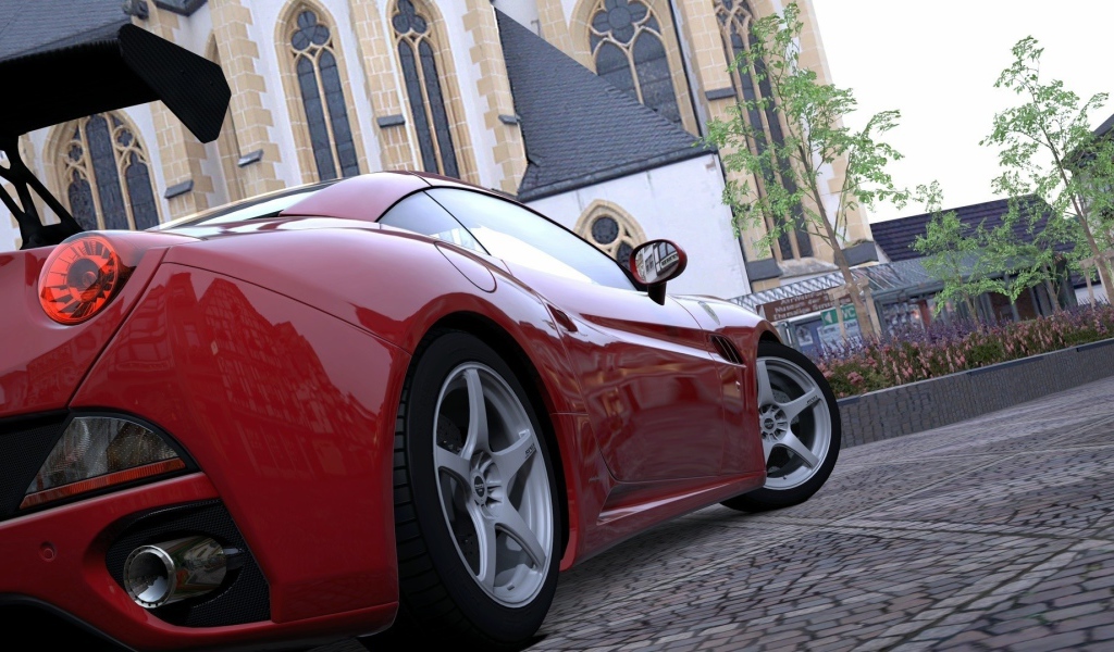 Красный спортивный автомобиль на площади у собора