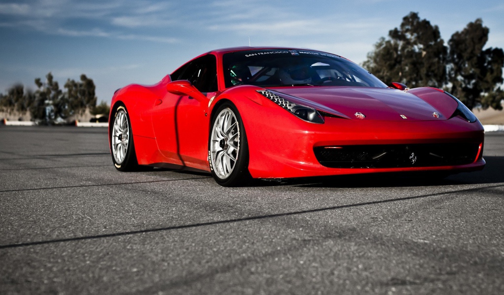 Красный спортивный автомобиль на гладком сером асфальте