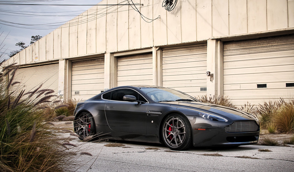 Автомобиль Aston Martin у складского здания