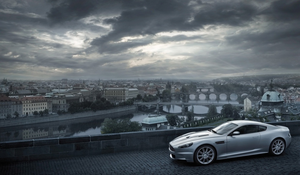 Серый Aston Martin на фоне города