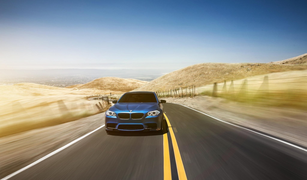 Голубой BMW мчится по шоссе в пустыне