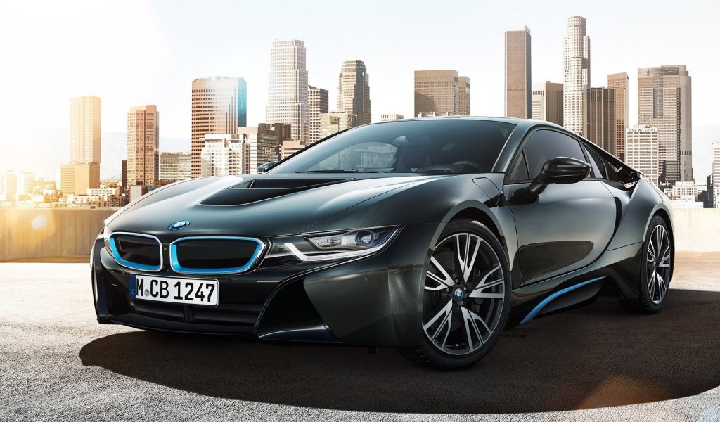 Спортивный черный БМВ на фоне мегаполиса