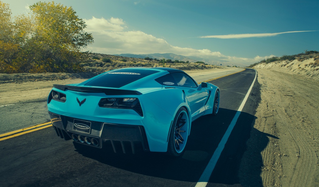 Голубой спортивный Chevrolet на шоссе в жаркой пустыне