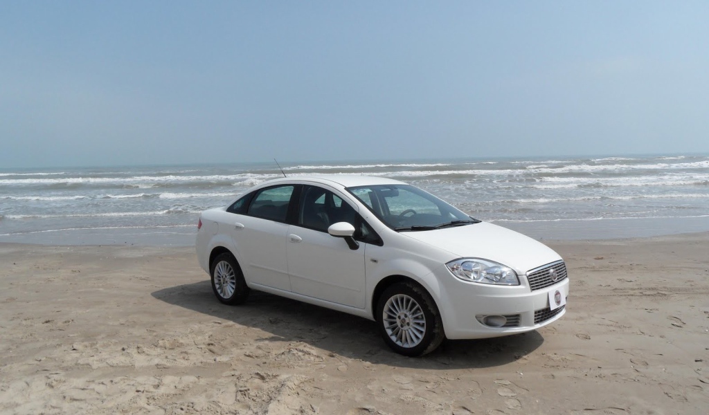 Белый Фиат на песке пляжа