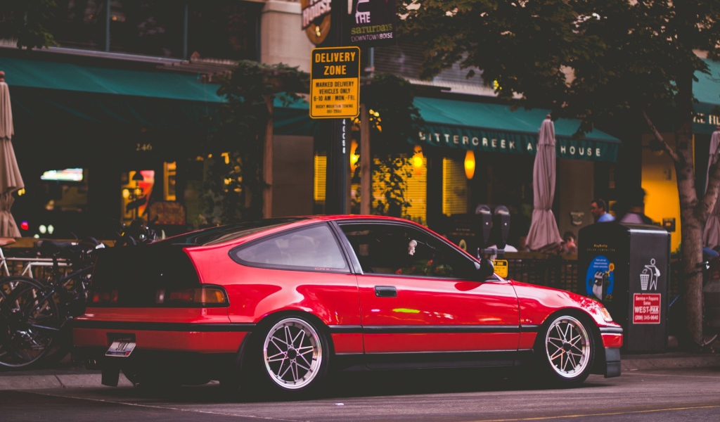 Красная Honda CRX стоит у уличного кафе