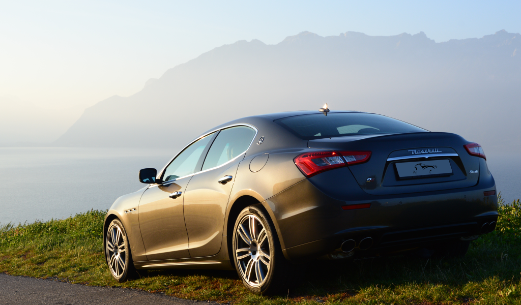 Коричневый Maserati на фоне гор