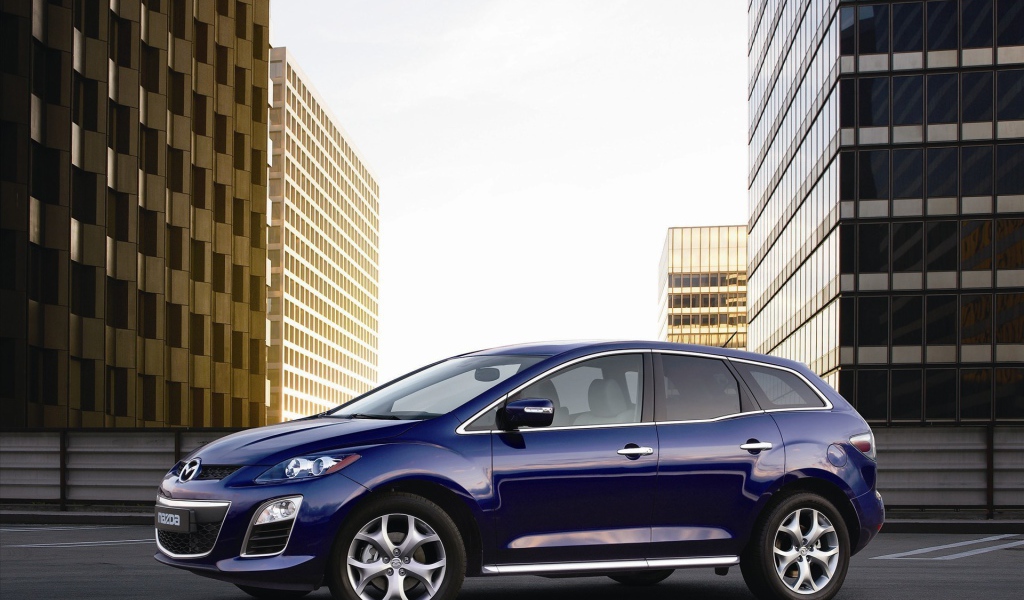 Семейный автомобиль Мазда на фоне городских зданий