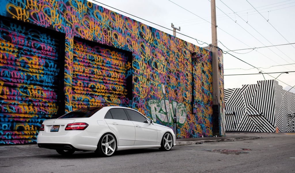 Белый Mercedes-Benz у раскрашенного гаража